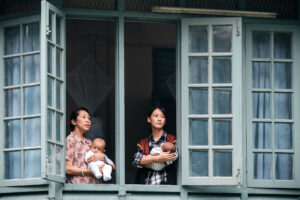 Fish Liew and co-star carrying babies in a still from Pavane for an Infant