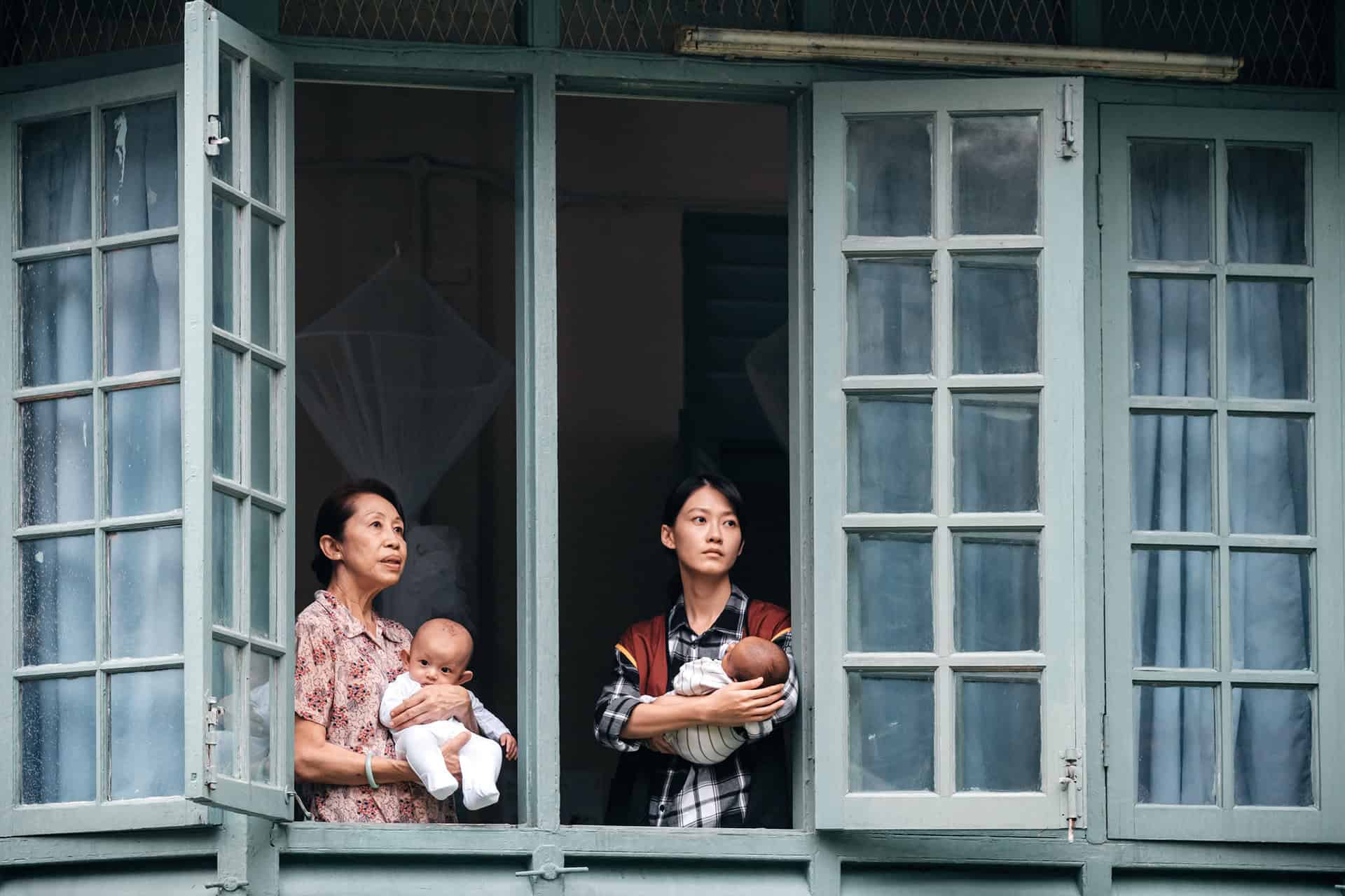 Fish Liew and co-star carrying babies in a still from Pavane for an Infant
