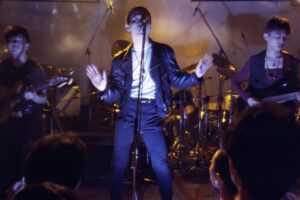 Still of a man on stage with a microphone from Beijing Bastards