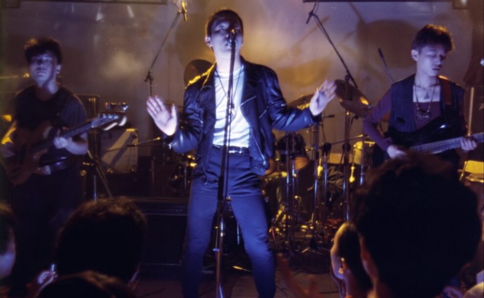 Still of a man on stage with a microphone from Beijing Bastards